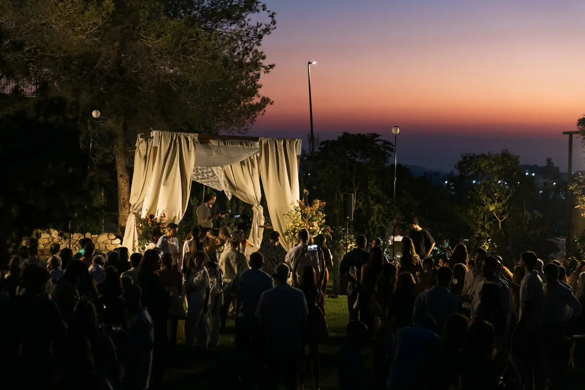 Les invités autour de la houppa au coucher du soleil