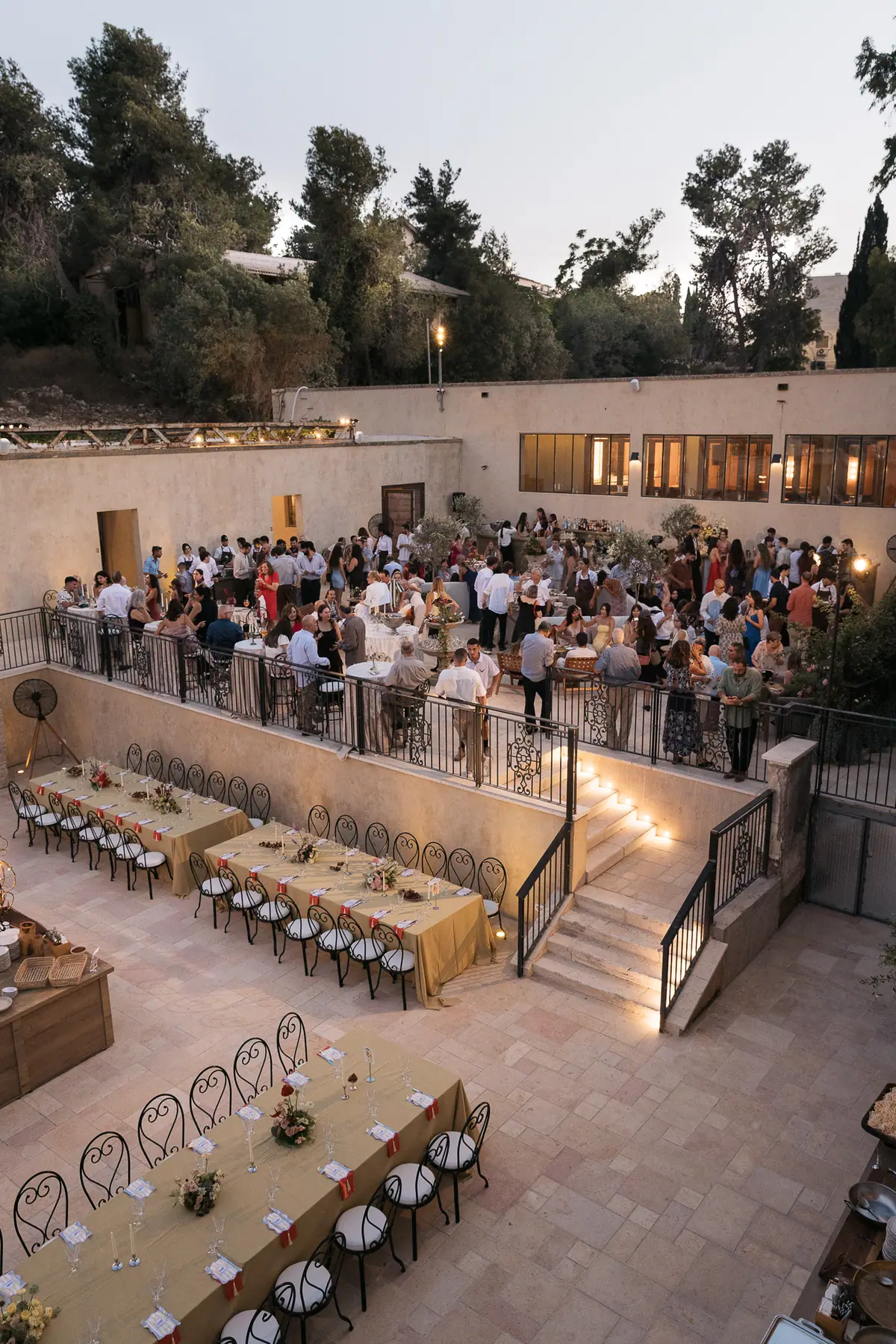 The courtyard from above at dusk, guests at long tables